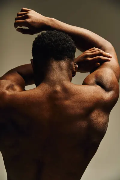 Un giovane e affascinante uomo afroamericano si alza fiducioso con le spalle allo spettatore, evidenziando il suo fisico scolpito. — Foto stock