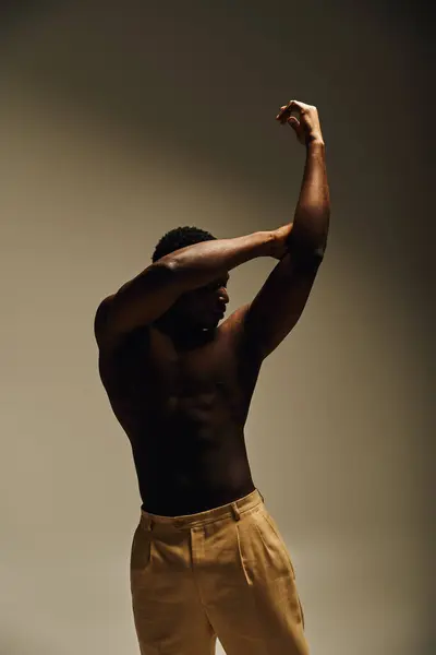 A young handsome african american man showcases his physique by posing topless, evoking confidence and elegance. — Stock Photo