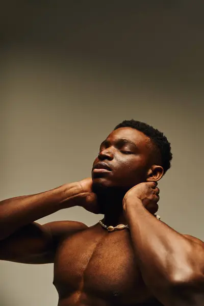 A young handsome African American man poses with a relaxed expression, showcasing his sculpted physique and personal style. — Stock Photo