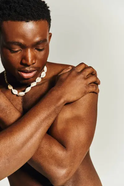 A young African American man stands confidently, showcasing his toned physique. — Stock Photo