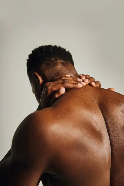A young, handsome African American man stands confidently, showcasing his toned physique. — Stock Photo