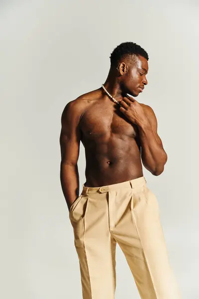A young African American man stands tall, showcasing his toned physique. — Stock Photo