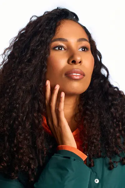 A beautiful woman poses thoughtfully, her curls framing a serene expression. — Stock Photo