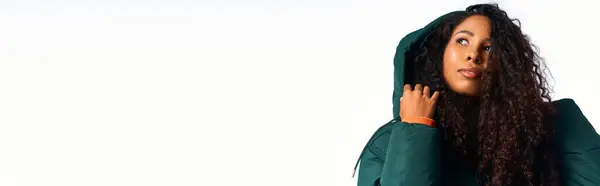 Woman with curly hair elegantly poses in stylish outerwear, radiating charm and grace. — Stock Photo