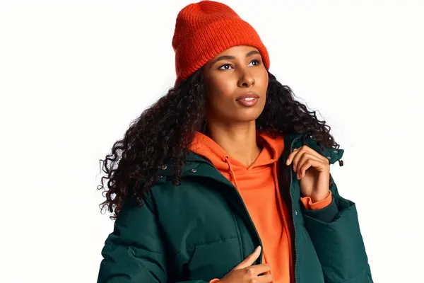 A stylish woman models trendy winter wear with confidence in a cozy setting. — Stock Photo