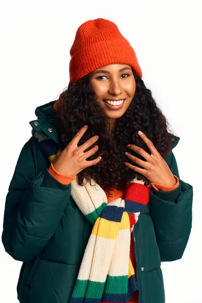 A cheerful woman in a vibrant hat and scarf smiles warmly while outdoors in winter attire. — Stock Photo