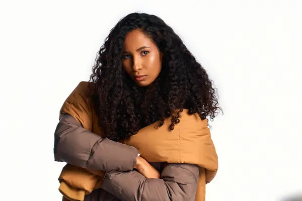 Curly haired beauty stands confidently in her warm, oversized outerwear, exuding charm. — Stock Photo