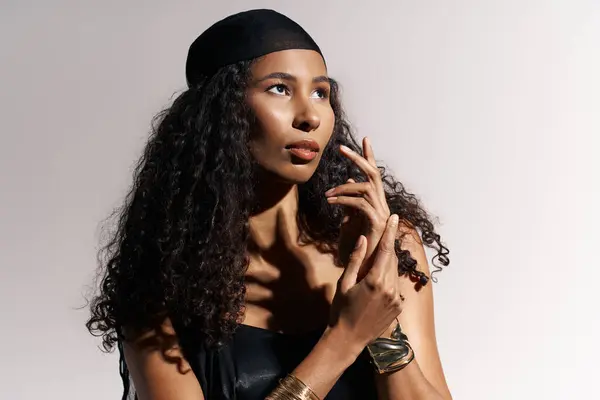 A striking woman with curly hair exudes elegance and poise, showcasing her natural beauty. — Stock Photo