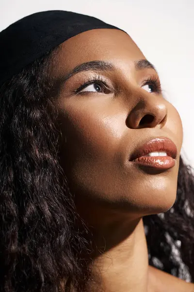 A stunning woman gazes upward, radiating confidence and elegance with a beautiful glow. — Stock Photo