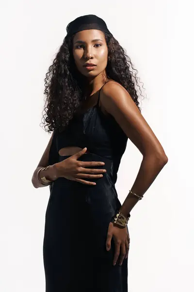 Curly haired woman stands tall in a stylish black outfit, radiating elegance and confidence. — Stock Photo