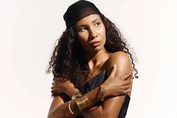 Curly haired woman displays beauty and grace in a chic black outfit and stylish accessories. — Stock Photo