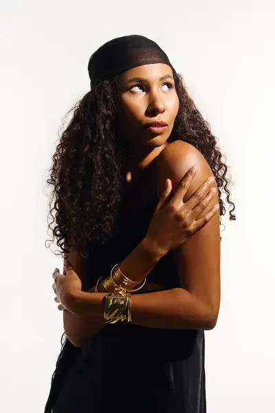 Beautiful woman with curly hair showcases elegance in a simple yet striking pose and style. — Stock Photo