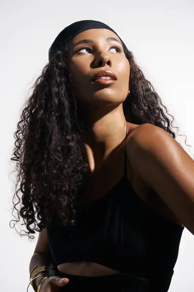 A beautiful woman with curly hair looks thoughtfully upwards in a serene atmosphere. — Stock Photo