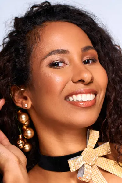A beautiful woman shows off a joyful smile, wearing elegant earrings and a stylish bow accessory. — Stock Photo