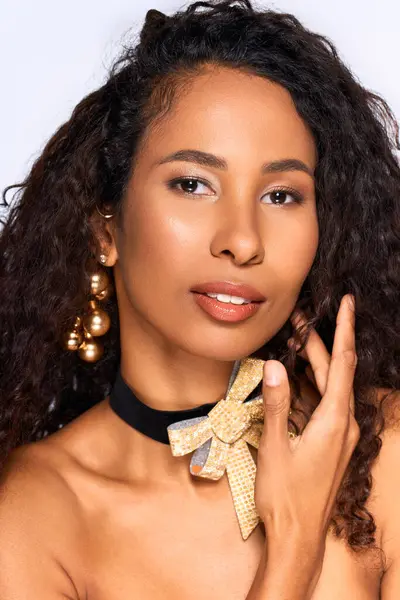 A stunning woman displays her charm and elegance with unique jewelry and a graceful pose. — Stock Photo