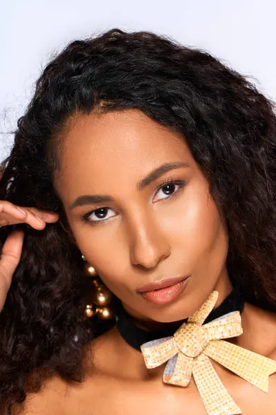 A stunning woman with curly hair presents a fashionable look while engaging with the camera. — Stock Photo