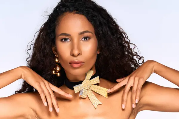 A beautiful woman exhibits stunning jewelry and poses gracefully in a minimalist setting. — Stock Photo