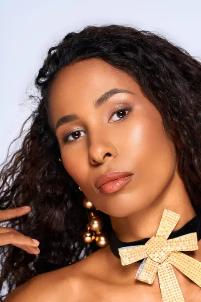 A woman with stunning curls highlights her beauty through a unique, fashionable accessory. — Stock Photo