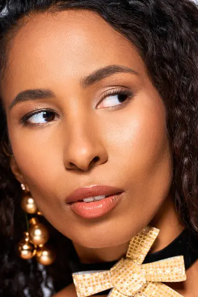 Warm light illuminates a stunning woman with curls, exquisite jewelry, and a captivating look. — Stock Photo