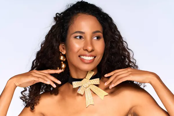 Mulher encantadora exibe sorriso radiante e jóias de ouro em um ambiente de estúdio, acentuando a elegância. — Fotografia de Stock