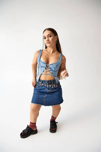 Fashionable young woman with short stature poses confidently in denim attire, celebrating diversity. — Stock Photo