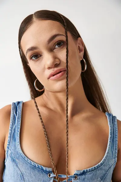 A young woman proudly showcases her unique fashion sense in a stylish denim outfit. — Stock Photo