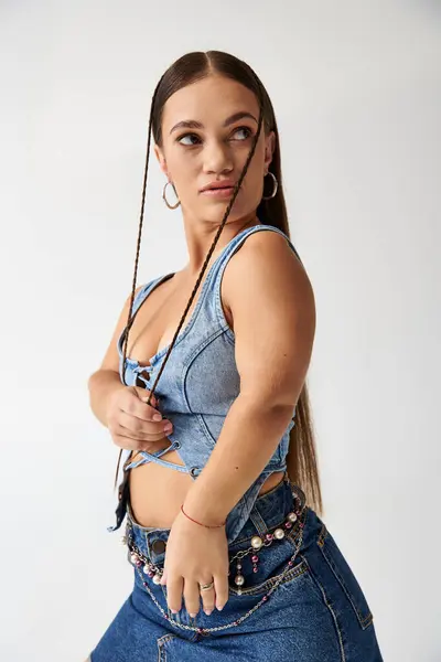 Una joven confiada con baja estatura posa en un traje de mezclilla elegante, celebrando la diversidad. - foto de stock