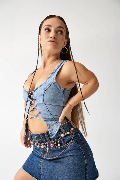 Young woman in trendy denim outfit poses gracefully, expressing fashion and individuality. — Stock Photo
