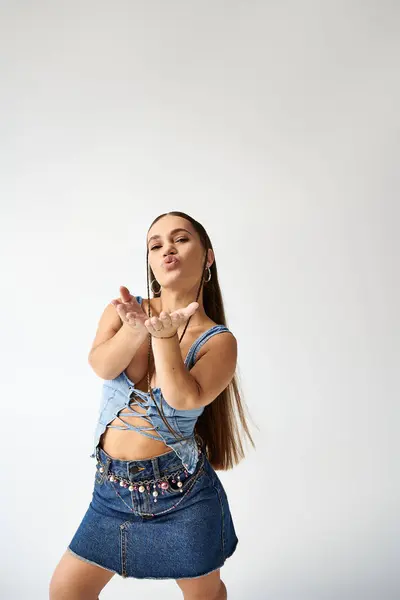 Une jeune femme avec achondroplasie en denim élégant pose ludique dans un environnement studio. — Photo de stock