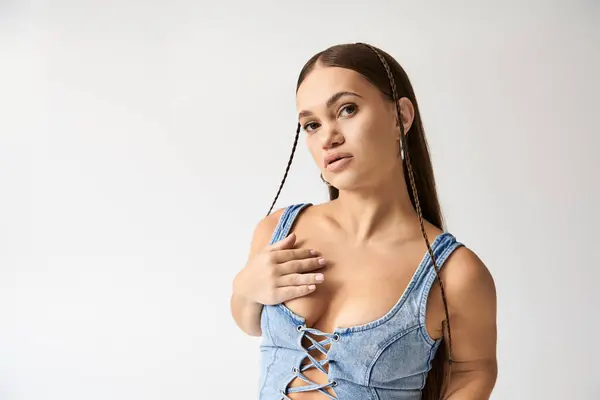 In a modern studio, a confident young woman with achondroplasia displays her trendy denim outfit with flair. — Stock Photo