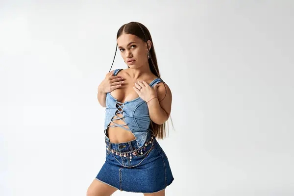 A young woman with short stature models stylish denim clothes in a vibrant studio atmosphere. — Stock Photo