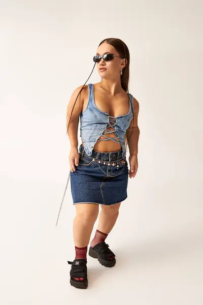 A confident young woman showcases her unique style in trendy denim, celebrating diversity. — Stock Photo