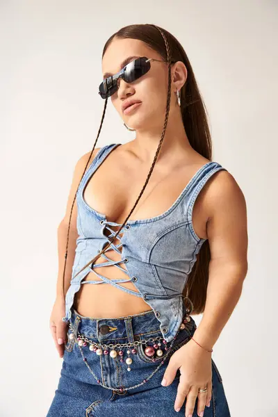 Short-statured model with achondroplasia showcases stylish denim attire in an artistic studio backdrop. — Stock Photo