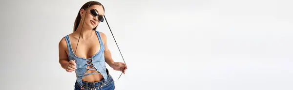 Young woman with achondroplasia in trendy denim clothes poses confidently in a bright studio environment. — Stock Photo