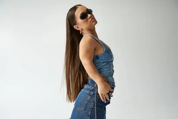 Charming young woman with achondroplasia exudes confidence in trendy denim clothing while posing in studio. — Stock Photo