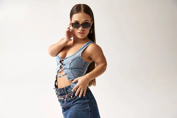 A confident young woman celebrates diversity in fashionable denim while posing beautifully. — Stock Photo