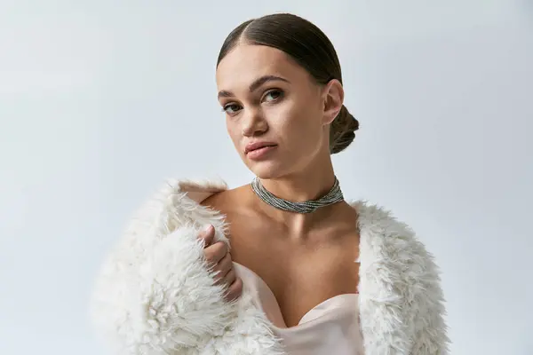Stylish young woman with achondroplasia in faux fur jacket and elegant dress poses confidently in studio lighting. — Stock Photo