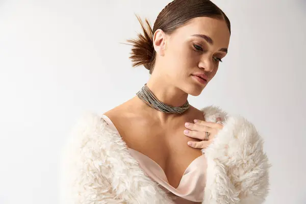 Young woman with achondroplasia in a chic dress and faux fur jacket radiates elegance in a stylish studio setting. — Stock Photo
