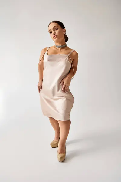 A young woman with short stature showcases fashion in a stylish dress within a studio. — Stock Photo