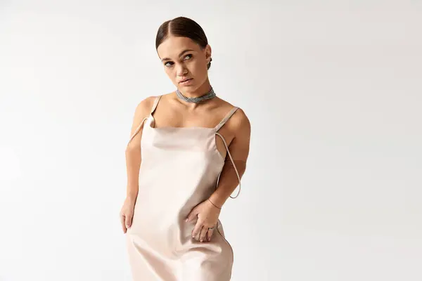 Une jeune femme à la stature courte met en valeur une belle robe dans un studio, respirant la confiance. — Photo de stock