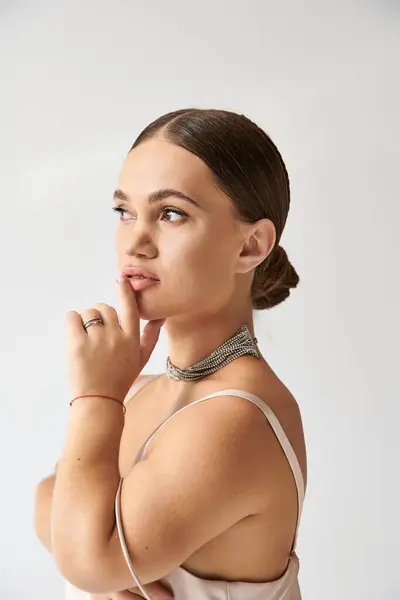 Mujer joven posa pensativamente en un vestido elegante, celebrando la inclusión y la diversidad en la moda. - foto de stock