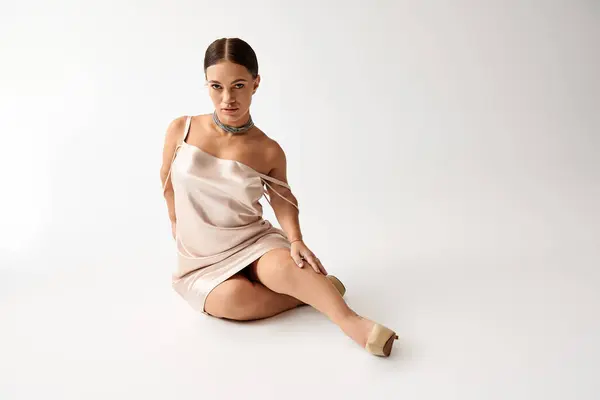 Una mujer pequeña posa elegantemente en un vestido elegante, celebrando la belleza y la diversidad. - foto de stock