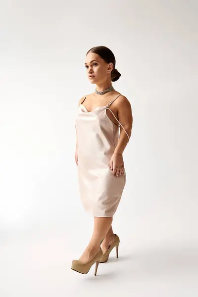 A confident young woman in a stunning dress poses elegantly, embodying inclusion in fashion. — Stock Photo