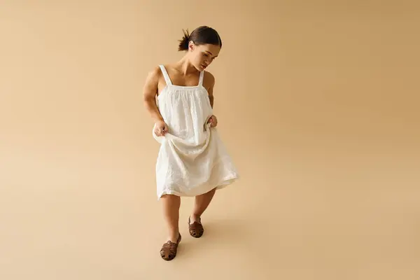 Jovem com modelos de baixa estatura um vestido branco elegante em um ambiente de estúdio quente. — Fotografia de Stock