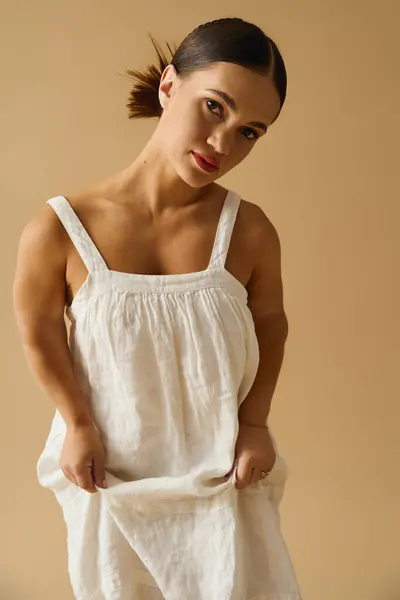 A young woman with short stature models a lovely dress in a studio, highlighting diversity. — Stock Photo