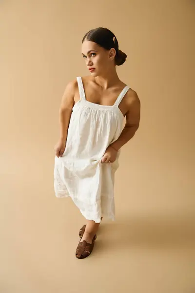 Charming girl in stylish dress poses gracefully in a studio, embracing diversity and inclusion. — Stock Photo