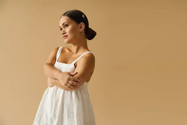 Junge Frau mit kurzer Statur strahlt Zuversicht aus, während sie in einem Studio ein elegantes Kleid präsentiert. — Stockfoto