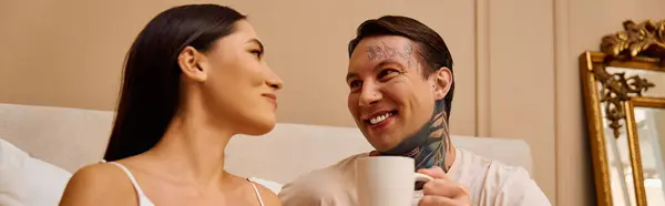 Young couple enjoy each others company while sipping coffee and exchanging smiles at home. — Stock Photo