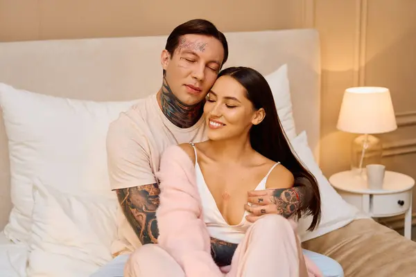 Young couple embraces warmly, enjoying an intimate moment in a softly lit bedroom. — Stock Photo