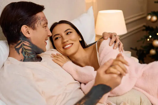 A loving man and woman embrace happily while relaxing on a soft couch, radiating warmth. — Stock Photo
